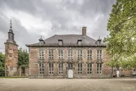 Rue animée de Courcelles avec camion de débouchage, bâtiments en briques typiques et verdure en arrière-plan