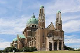 Ouvrier débouchant une canalisation dans une rue pavée de Koekelberg avec la basilique en arrière-plan Débouchage Koekelberg