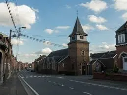 Scène urbaine à Oupeye avec rue bordée de maisons typiques, contexte lié au service de débouchage local reconnu.