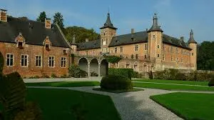 Paysage de Rixensart avec équipe de débouchage en action devant une maison typique, verdure environnante visible.